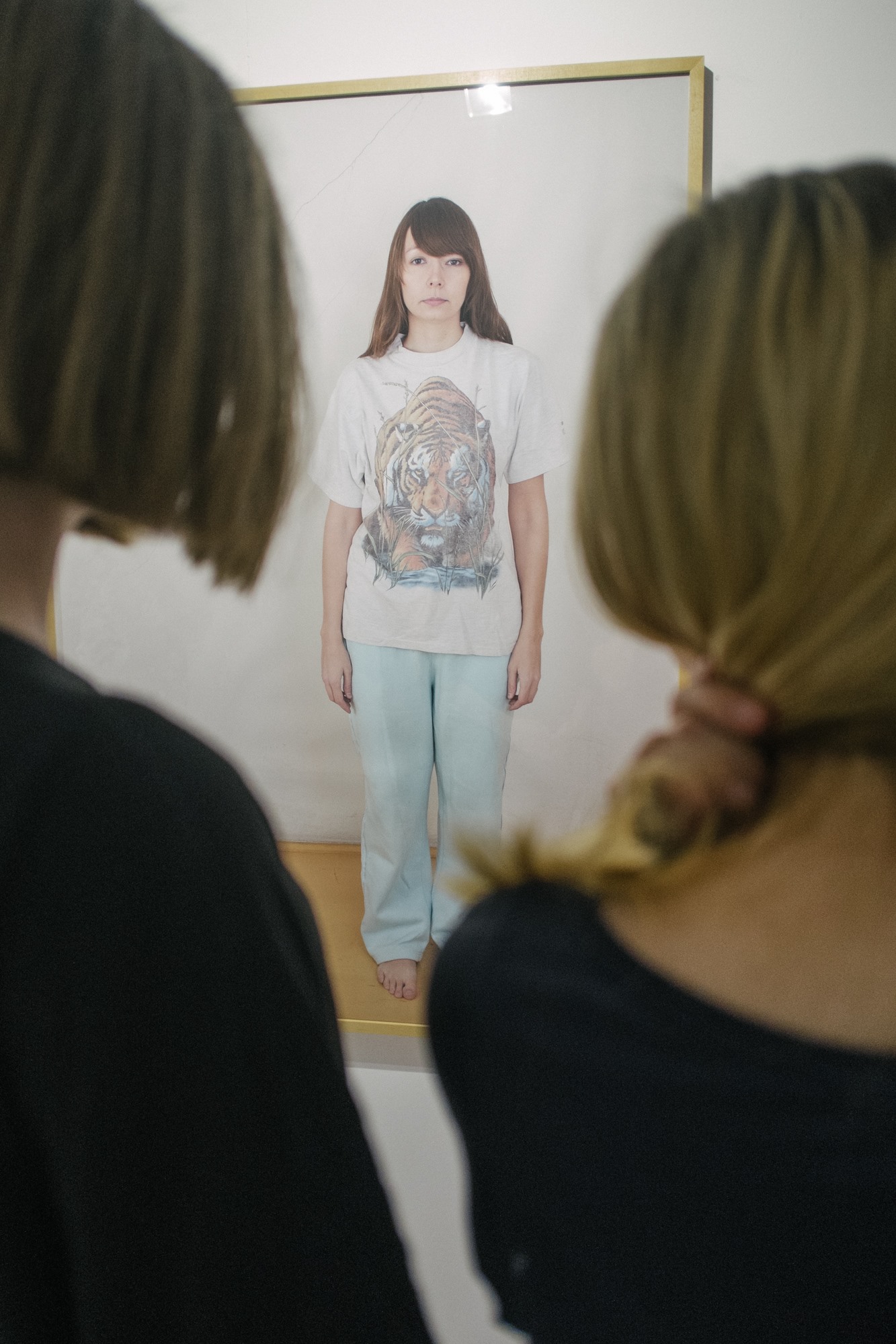 Osoby oglądają fotografię przedstawiającą postać w jasnym stroju.